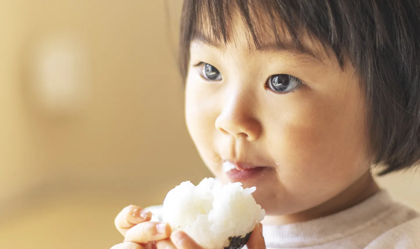 おにぎりをほおばる子ども